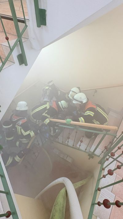 Feuerwehrleute auf der Treppe, Qualm